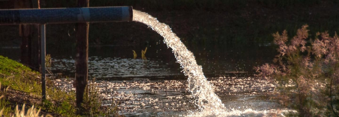 Water spilling out from a pipe into a lake